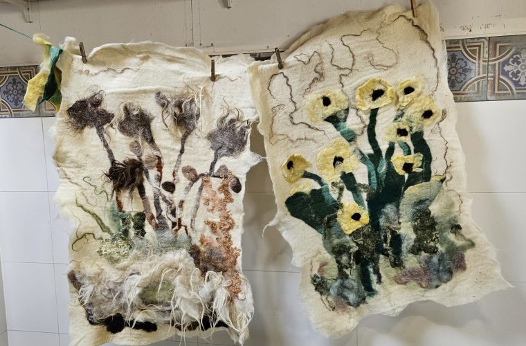 Handen die wol vilten met traditionele vilttechnieken in het atelier van Lana Wolatelier in Warns